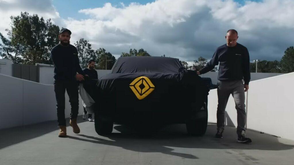 https___www.carscoops.com_wp-content_uploads_2023_06_Rivian-R2-Teaser-1-1024x576.jpg.a4b28f3bcd7d7e2b2dad3bfc3d121e96.jpg